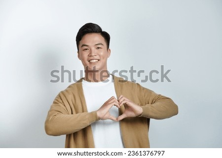 Portrait happy young asian man makes heart gesture, asks to be my valentine.