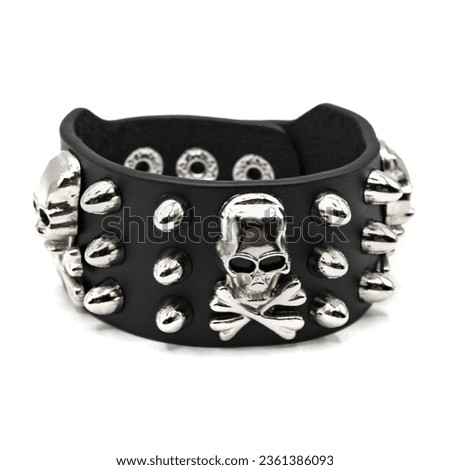 Black leather bracelet with spikes, skulls and bones. jolly roger Pirate Style, filibuste. An accessory for rockers, bikers, metalheads, goths and punks. Steampunk style. Close-up subject photography. Royalty-Free Stock Photo #2361386093