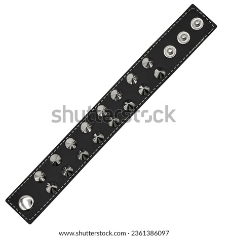 Black leather bracelet with spikes, holnitenes. An accessory for rockers, bikers, metalheads, goths and punks. Steampunk style. Close-up subject photography. Royalty-Free Stock Photo #2361386097