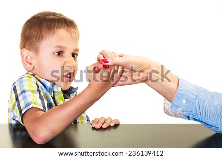 Family, children and motherhood concept. Son confronts his middle aged mother. Woman and little boy arm wrestling having fun.