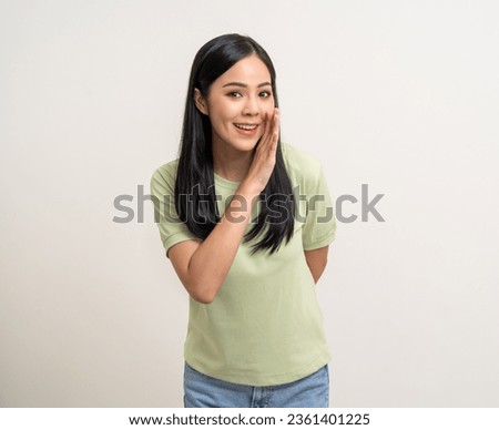 Happy beautiful young asian woman whispering some secret gossip. Excited pretty latin girl index finger on mouth standing pose on isolated white background. Royalty-Free Stock Photo #2361401225