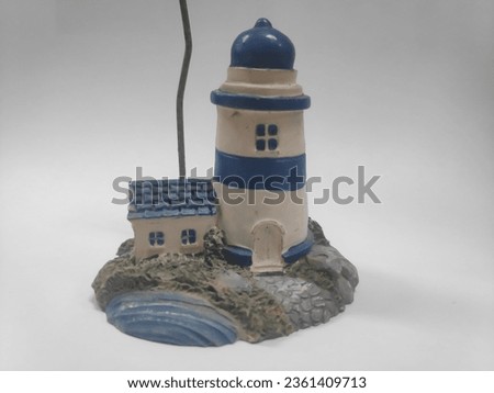 Miniature lighthouse: a beacon of elegance on a canvas of purity