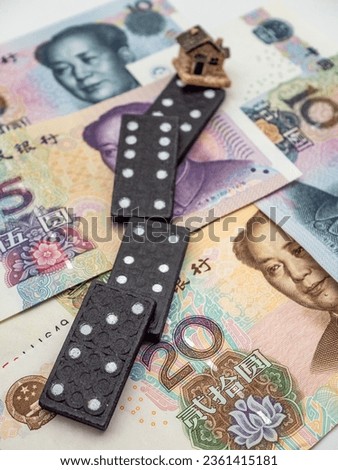 domino effect and house on chinese yuan currency background concept photo