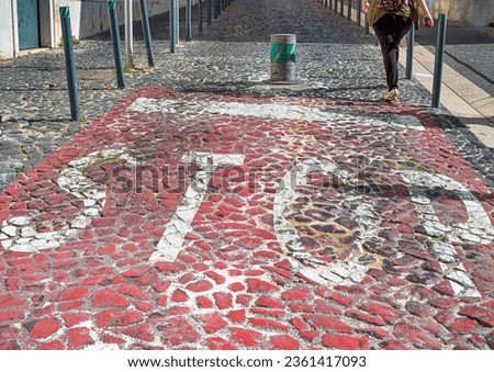 Portuguese Pavement Known as Calçada Portuguesa Made of Small White-Red-Black Stones in Mosaic Pattern With Stop Sign and Pedestrian. Horizontal Image