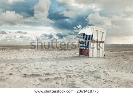 Hooded beach chair on the beach at the north sea Royalty-Free Stock Photo #2361418775