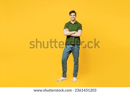 Full body young smiling cheerful satisfied happy man he wears green t-shirt casual clothes look camera hold hands crossed folded isolated on plain yellow background studio portrait. Lifestyle concept Royalty-Free Stock Photo #2361431203