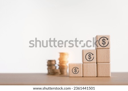refinance, saving money for finance accounting concept, different size of  dollar sign in circle on stack of wooden cube blocks and blurred coins