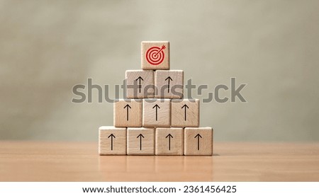 Wooden blocks with targets aiming the dartboard and arrows up onto the tabletop. Goals, business success and project progress, value growth, processing, finance concepts, marketing