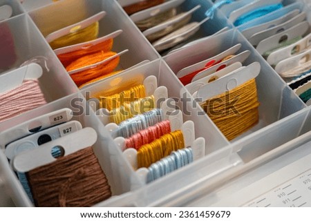 Plastic storage box for floss. Threads on the spool. Different colors. Cotton floss for embroidery and needlework Royalty-Free Stock Photo #2361459679