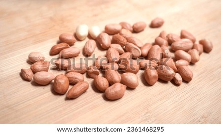 Close-up photo of group of fresh nuts with shelled peanuts on wooden base. stock photo