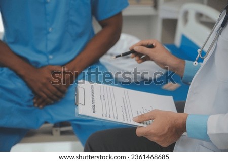 Close up of doctor sitting on bedside of male patient in hospital