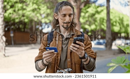 Young hispanic man tourist shopping with smartphone and credit card at park