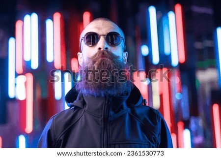 Portrait brutal man in glasses. Augmented reality game, future technology, AI concept. VR. Neon blue and red light. Dark background.