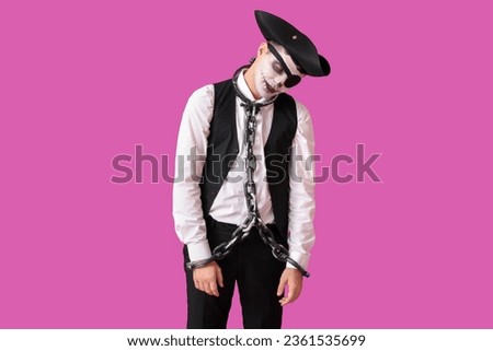 Young man dressed for Halloween as pirate with chain on color background