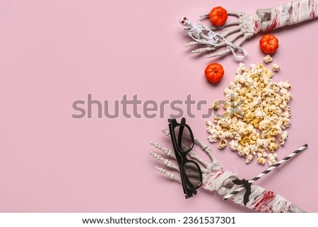 Composition with tasty popcorn, 3D glasses, skeleton hands and pumpkins for Halloween celebration on pink background