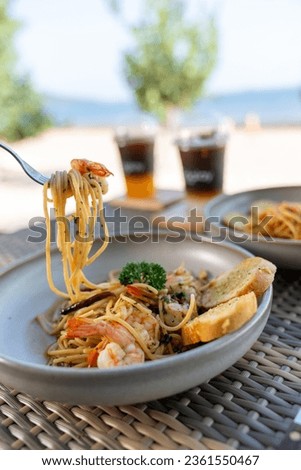 Spaghetti, pizza, french fries, beef steak on a wooden plate on the beach