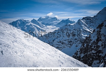 Mountain snow slopes in winter. Snowy mountain scene. Mountain snow peaks. Snow covered mountain peaks Royalty-Free Stock Photo #2361550489