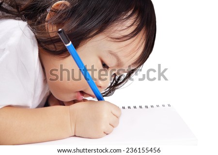 Asian baby concentrates to write a letter on a book isolated on white background