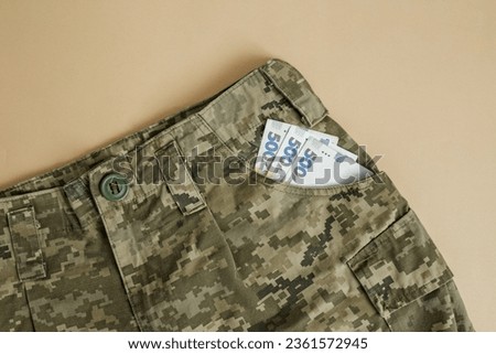 Ukrainian hryvnia in uniform pocket. Military pay concept. Money of Ukraine. Military uniform