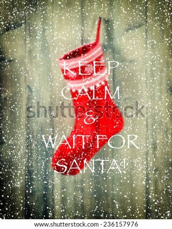christmas stocking. blurred background with hanging red sock and sample text KEEP CALM & WAIT FOR SANTA! retro style toned picture