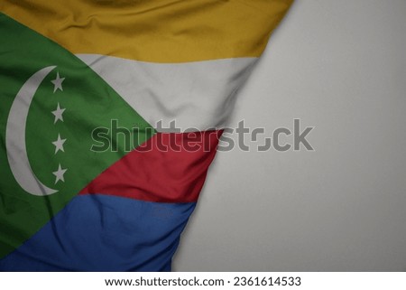 big waving national colorful flag of comoros on the gray background. macro