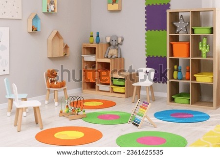 Child`s playroom with different toys and furniture. Cozy kindergarten interior Royalty-Free Stock Photo #2361625535