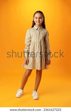Photo of teen girl smiling portrait against yellow background in studio