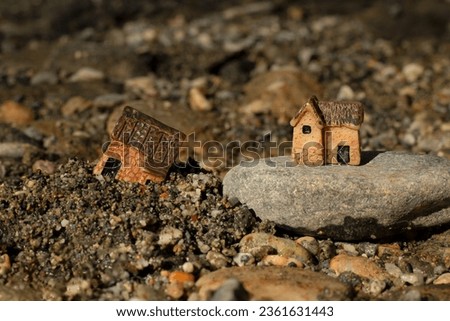 Two miniature houses in sand and on rock (stone). Close-up. Wise and solid foundation gospel parable of Jesus Christ, obedience, and faith in God. Christian biblical concept. Royalty-Free Stock Photo #2361631443