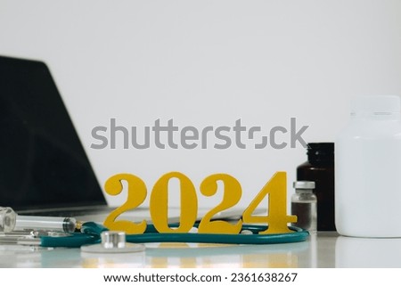 Happy new year 2024 for health care and medical concept.Golden wood numbers with Stethoscope,Laptop,Syringe,Medical bottle on white background.