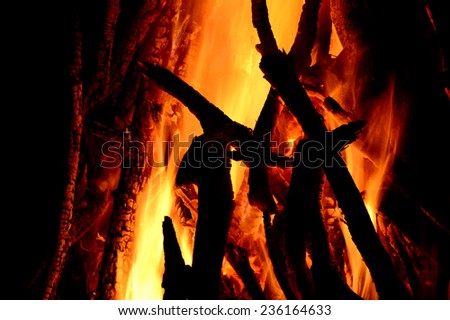 Close up of burning logs in the fireplace on black background