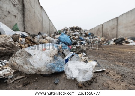 Landfill site, a pile of stinky different junk disposal in the concrete section for unsorted waste materials Royalty-Free Stock Photo #2361650797