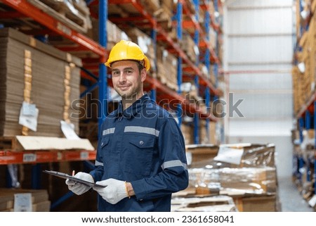 Portrait of man warehouse worker wearing uniform and helmet safety standing with clipboard for checking stock products on shelves in warehouse factory store. Logistics, Distribution Center concept