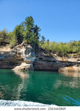 Pictured Rocks National Lakeshore is situated in the Upper Peninsula of Michigan, U.S. It has extensive views of the hilly shoreline with picturesque rock formations, waterfall and sand dunes.