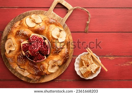Jewish Holidays - Rosh Hashanah or Rosh Hashana. Pomegranate, apples, honey and round challah on  old wooden red table background. Jewish Autumn celebration. Shana Tova. Yom kippur concept. Top view