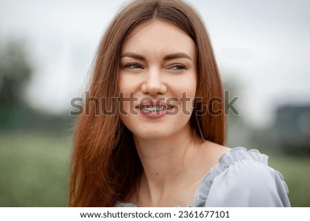 The smile of a young and beautiful girl with braces on her white teeth. Straightening of crooked teeth with the help of a bracket system. Malocclusion. Dental care. Smooth teeth and a beautiful smile Royalty-Free Stock Photo #2361677101