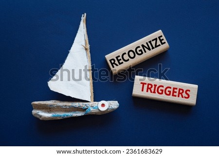 Recognize triggers symbol. Concept words Recognize triggers on wooden blocks. Beautiful deep blue background with boat. Business and Recognize triggers concept. Copy space.