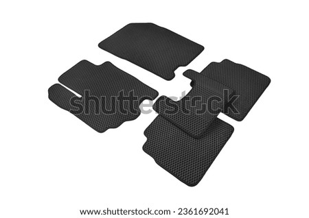 Set of black Kinetics car mats with blue trim isolated on a white background