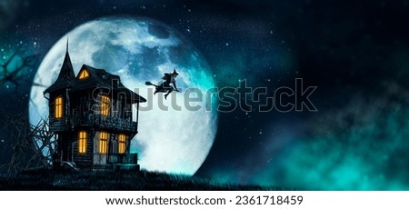Halloween Witch flying on a broomstick. Female wizard fairy character for All Saints' Day. Fantasy gothic red-haired sorceress girl dressed in black carnival costume. Enchantress woman Royalty-Free Stock Photo #2361718459