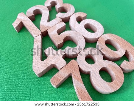 wooden numbers in-line , selective focus numbers green background . Top view isolated photo.