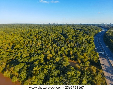 stunning aerial shot of miles of lush green trees, the freeway, the Chattahoochee river at sunset with powerful clouds at the Chattahoochee River Recreation Area in Sandy Springs Georgia	