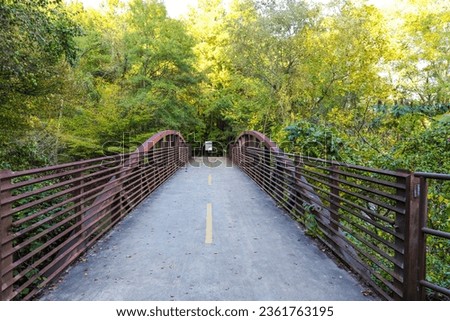 a bridge over a river with metal railing and lush green trees at the Chattahoochee River National Recreation Area in Sandy Springs Georgia	 Royalty-Free Stock Photo #2361763195