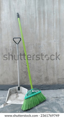 A pair of broom and dust container for house maintenance.  Royalty-Free Stock Photo #2361769749