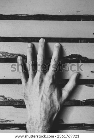 Abstract photograph of a left hand weather wooden slats in black and white