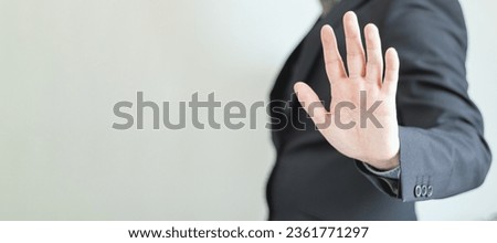 Web Banner of a businessman with hand in stop sign on a plain background. Rejection and warning, Unrecognizable elegant man in profile showing his open hand. Five fingers.