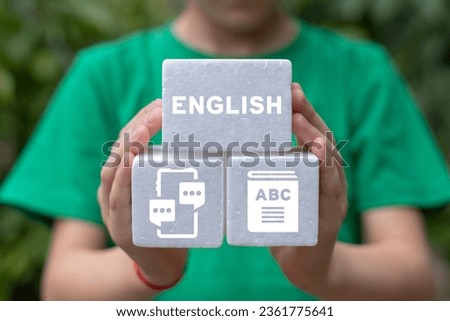 Little girl holding white foam blocks with icons sees word: ENGLISH. I love english concept. English language learn. Online course.