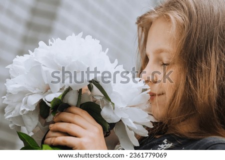 Photography, close-up face portrait of a red-haired beautiful happy girl, a child with white peonies flowers.