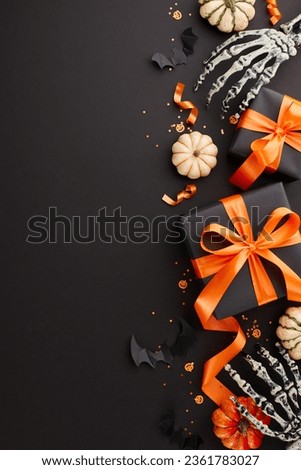 Crafting Halloween delight with heartfelt gift ideas. Top view vertical photo of skeleton hands, presents, pumpkins, spooky decor, confetti on black background with ad placement