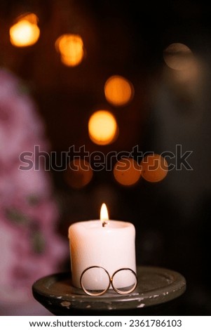 Photo of a wedding ring, in the photo there is a ring and candles. Ideal for romantic backgrounds.