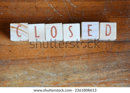 Photo of wooden blocks that make up the vocabulary "CLOSED" in English