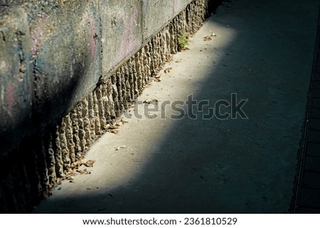 Ray of sun on a stone wall and sidewalk